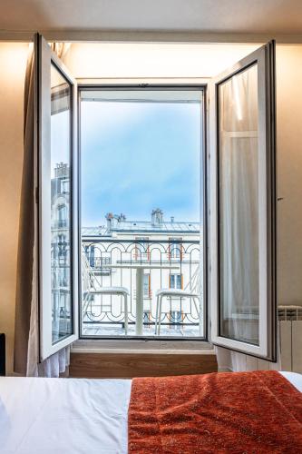 a bedroom with a large window with a view at Hôtel De Venise in Paris