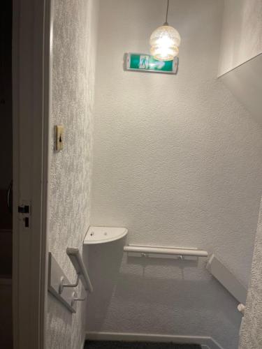 a bathroom with a toilet and a light on the wall at Ermihouse in Sheffield