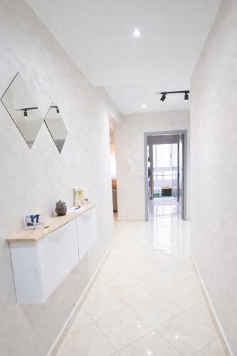 a large white room with a counter and a tile floor at Cozy appartement à Mohammedia in Mohammedia