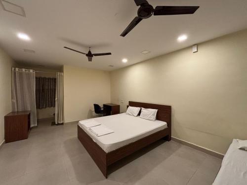 ein Schlafzimmer mit Bett und Deckenventilator in der Unterkunft Aathidya Lodge in Ādoni