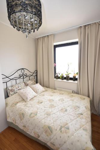 a bedroom with a bed and a chandelier at apartmaji LEJARDIN in Škofljica