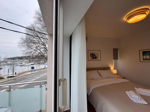 a bedroom with a bed and a view of a street at Apartments Ivančić in Novi Vinodolski