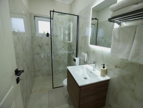 a white bathroom with a shower and a sink at The Swan Nest 2 in Pogradec