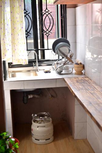 a kitchen counter with a sink and a window at Peryn Suites Kinubi, Hoima City, Uganda in Hoima