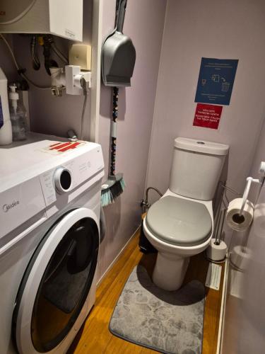 a bathroom with a toilet and a washing machine at Casa da praia fluvial o Moinho in Benquerença