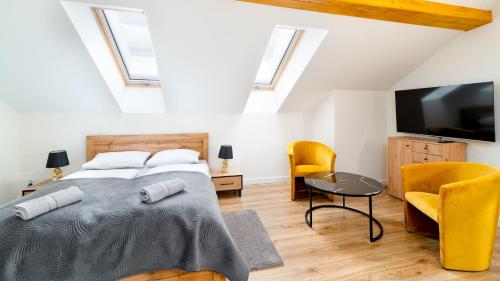 a bedroom with a bed and a flat screen tv at Apartament Komfort Lux in Karpacz