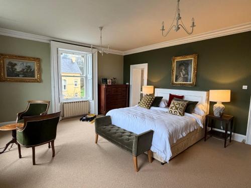 a bedroom with a bed and a chair and a window at Oakhurst Guesthouse in Cobh