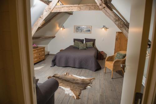 1 dormitorio con 1 cama y suelo de madera en Petrus Wittebrood Hoeve, en Dikkelvenne