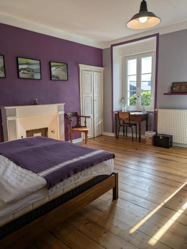 une chambre avec un lit, une cheminée et une table dans l'établissement Le Derrien, à La Roche-Derrien