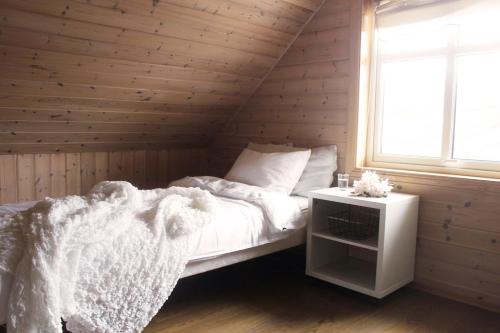 a bedroom with a bed and a window at Hus ved sjøen på Bømlo in Bømlo