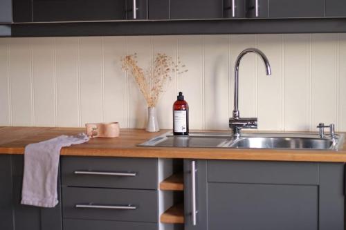 a kitchen counter with a sink and a bottle of wine at Hus ved sjøen på Bømlo in Bømlo