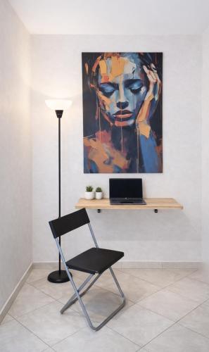 a chair in front of a painting of a woman at Cozy appartement à Mohammedia in Mohammedia