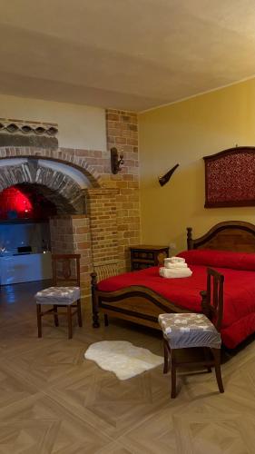 a bedroom with a red bed and two chairs at Rabat Home Luxury in Tursi