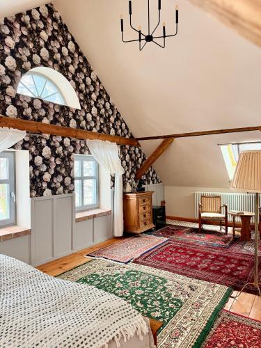 an attic bedroom with a bed and a chandelier at Siedlisko Dobrych Snów in Stare Juchy