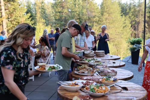 a group of people standing around a buffet of food at Genesis Mountain Farm in Sandpoint