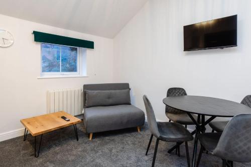 a waiting room with a table and chairs and a tv at Loft-Style Studio with Skylights and Parking in Doncaster