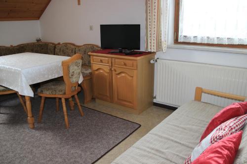 a living room with a table with a tv on it at Schröckerhof in Mariapfarr