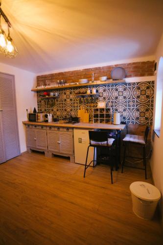 a kitchen with a counter and a table with chairs at Zöldre Néző Vendégház in Letkés