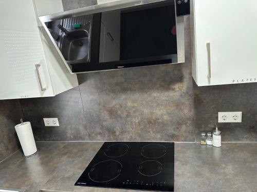 a kitchen with a microwave and a stove top oven at Guest House BiBi-Lux in Ilsfeld