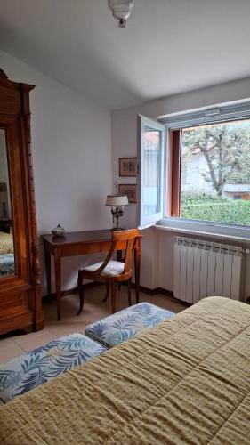 a bedroom with a desk and a bed and a window at A casa di Berta in Pietrasanta