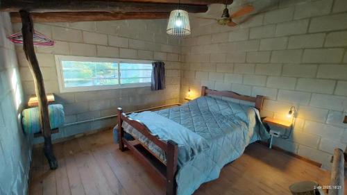 a bedroom with a bed and a window at Kima III in Huerta Grande