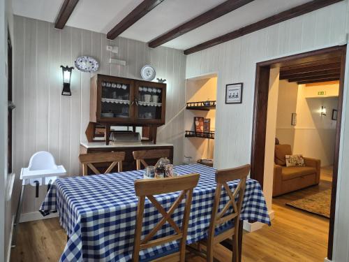 a dining room with a table with a blue and white checkered table cloth at Refúgio no Vale das Furnas - Casa do Sossego in Furnas