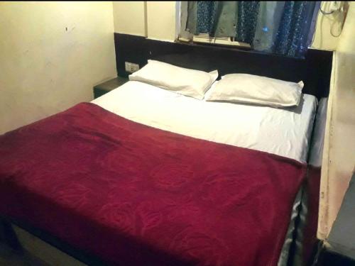 a bedroom with a bed with a red blanket at Hotel Mahi in Jaipur