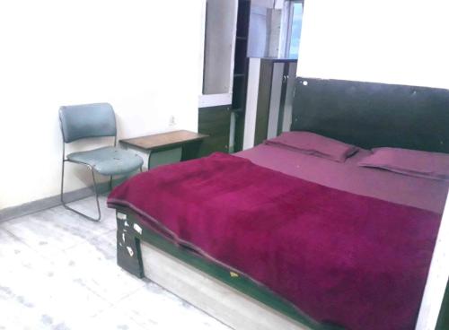 a bedroom with a large bed and a chair at Hotel Mahi in Jaipur