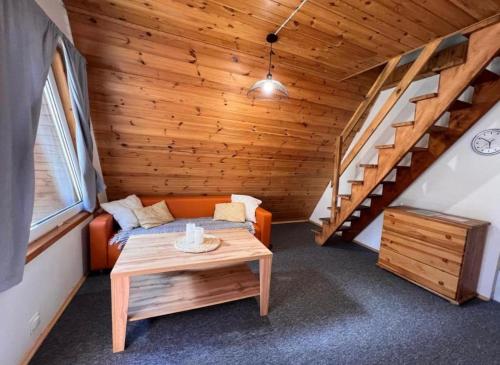 a room with a bed and a table and stairs at Domki Sosnówka-Kaszuby in Zgorzałe