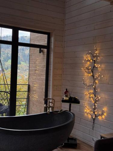 a bathroom with a tub and a tree with lights at Drin-lux-cotteges in Slavske
