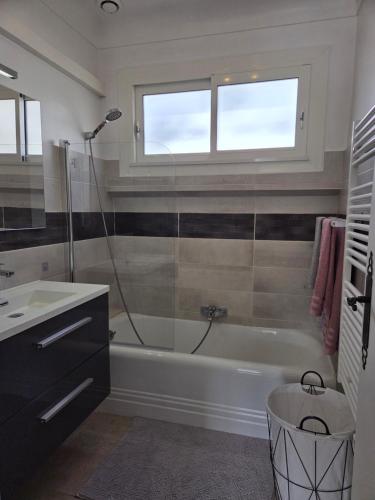 a bathroom with a bath tub and a sink at Maison Valras Plage très bon emplacement in Valras-Plage