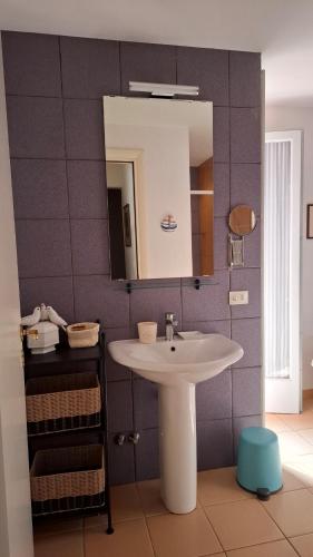 a bathroom with a white sink and a mirror at A casa di Berta in Pietrasanta