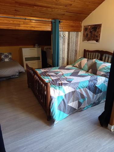 a bedroom with a bed with a quilt on it at Chez Sylvia in Saint-Julien-du-Pinet