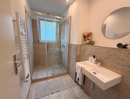 a bathroom with a shower and a sink and a mirror at Ferienwohnung Oppenheim in Oppenheim