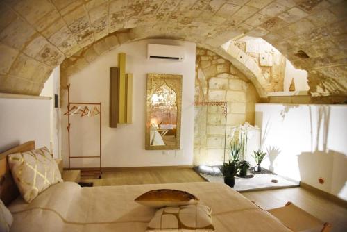 a bedroom with a large bed and a stone wall at La SignoraDelDuomo in Lecce