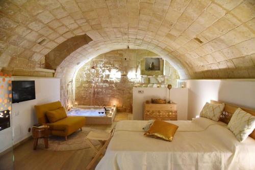 a bedroom with a large bed and a stone wall at La SignoraDelDuomo in Lecce