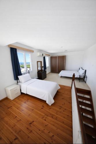 a large bedroom with two beds and a staircase at The Horse Farm Hotel in Kyrenia
