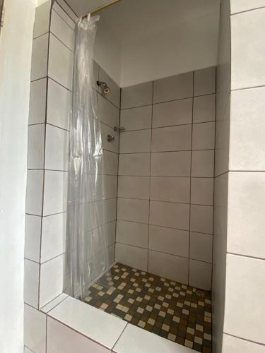 a bathroom with a shower with a tiled floor at Manasseh in Riversdale