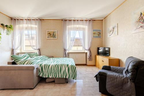 a bedroom with a bed and a couch and two windows at Trieste Sweet in Trieste