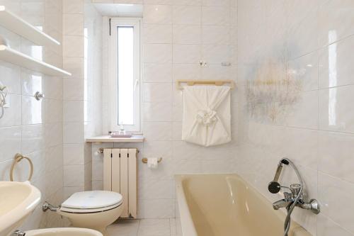 a bathroom with a toilet and a tub and a sink at Trieste Sweet in Trieste