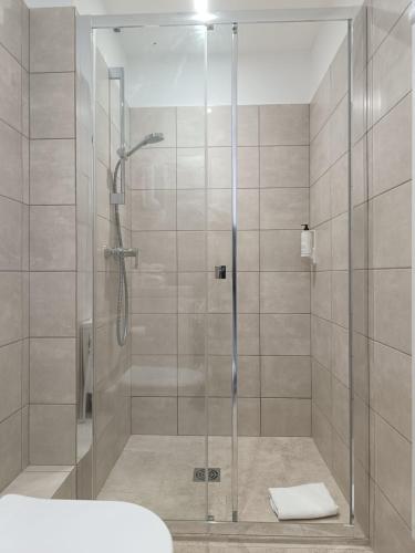 a shower with a glass door in a bathroom at Hôtel La Petite Bohème in Le Lavandou