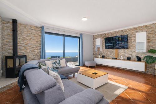 a living room with two couches and a fireplace at Villa Werner by Madeira Dream Stays in Ponta do Pargo