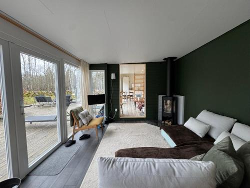 a living room with green walls and a couch at Cabin in the forest with Spa and Sauna in Västra Torup