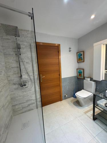 a bathroom with a shower with a toilet and a glass door at Hilda's Queen Room private bathroom in Roses