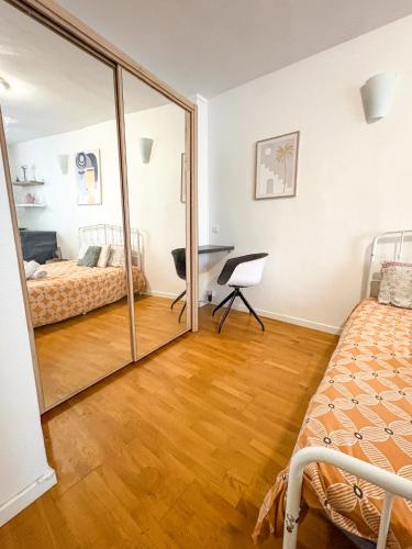 a mirror in a bedroom with two beds and a desk at À deux pas du métro in Paris