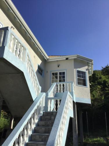 a white house with stairs in front of it at chill spot on the green in Belmont