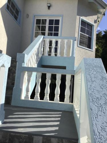a white house with stairs and a door at chill spot on the green in Belmont