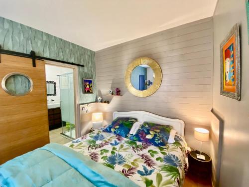 a bedroom with a bed and a mirror at Domaine Ô Clair de Lune - Chambres d'Hôtes et Gîtes à Sarlat - Accès Cité Médiévale 5 minutes à pied - Parking - SPA & Massages en option - Piscine de saison in Sarlat-la-Canéda