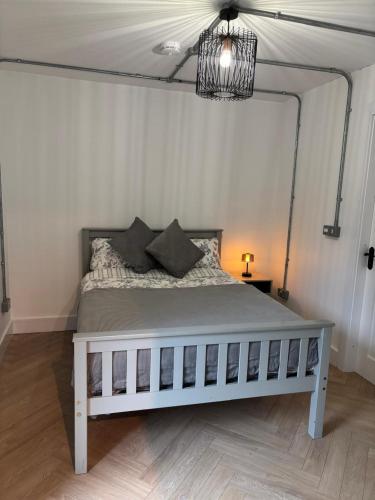 a bedroom with a white bed with a chandelier at Rosscarbery in Temple Bridge