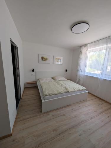 a white bedroom with a bed and a window at Wagramzimmer - Satzingerhof in Großwiesendorf